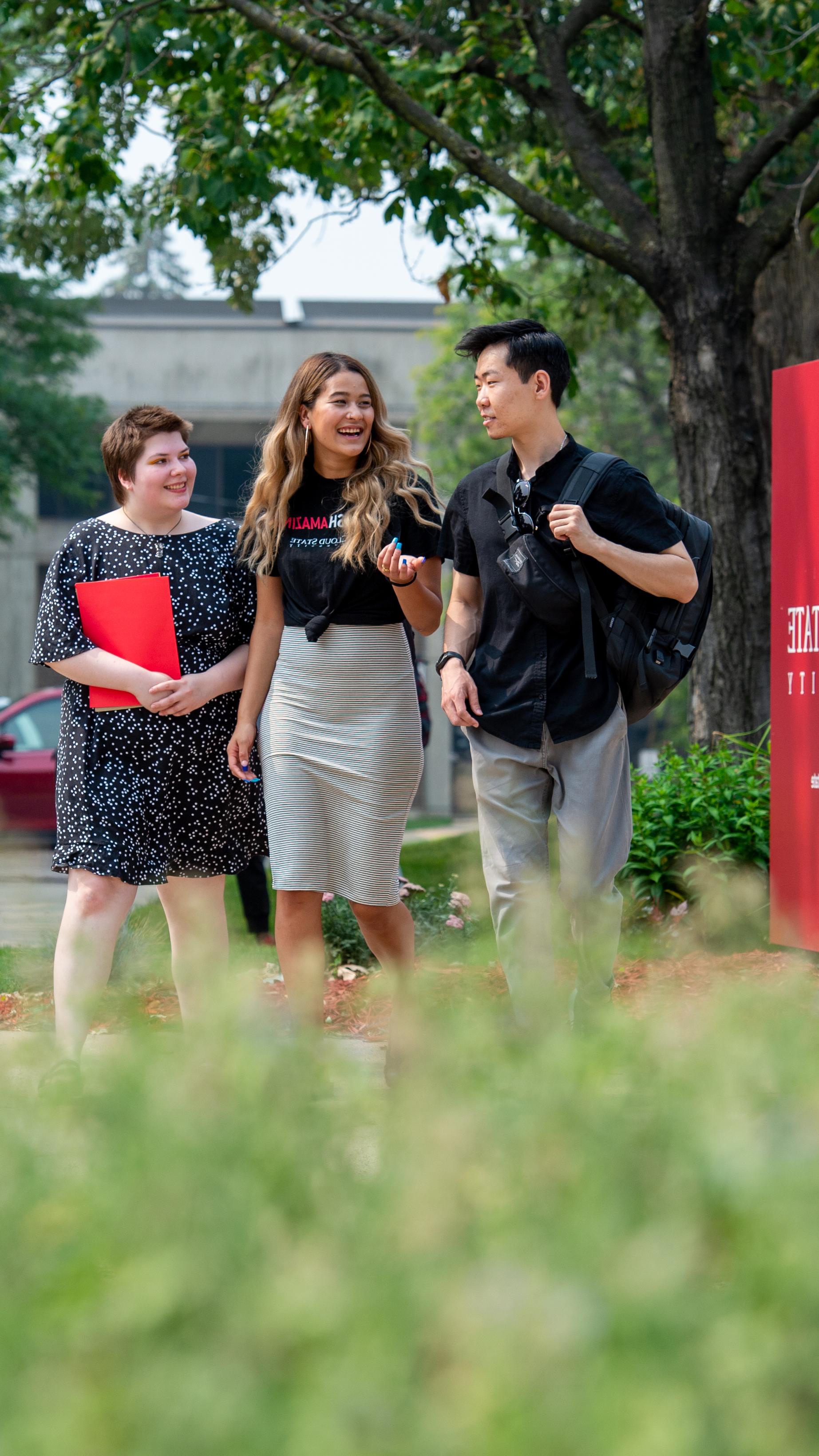 Students walking by campus sign