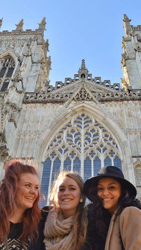 Student smiling in front of European cathedral