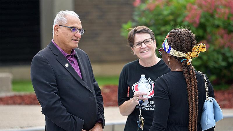 Three people talking on St. Cloud State University Campus