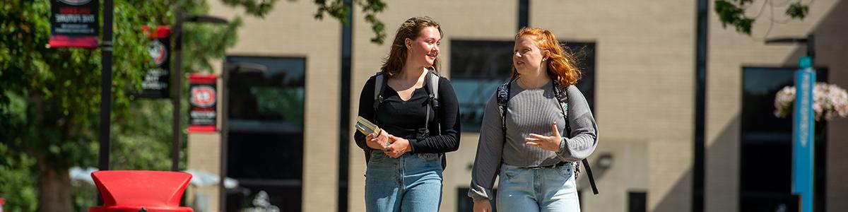 Two students walking on campus