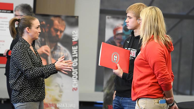 Parent, prospective student talking to staff member