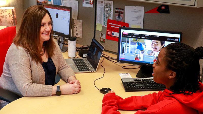 Student and advisor talking at desk